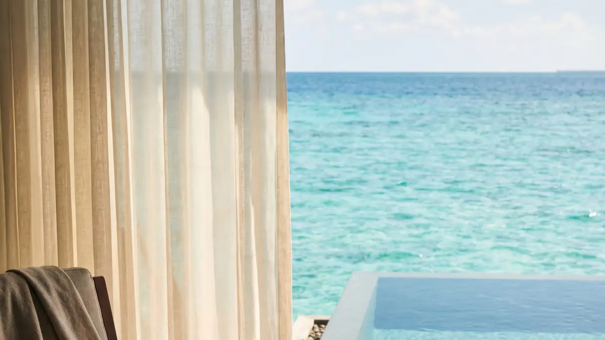 A Maldives overwater villa with a private infinity pool and turquoise lagoon